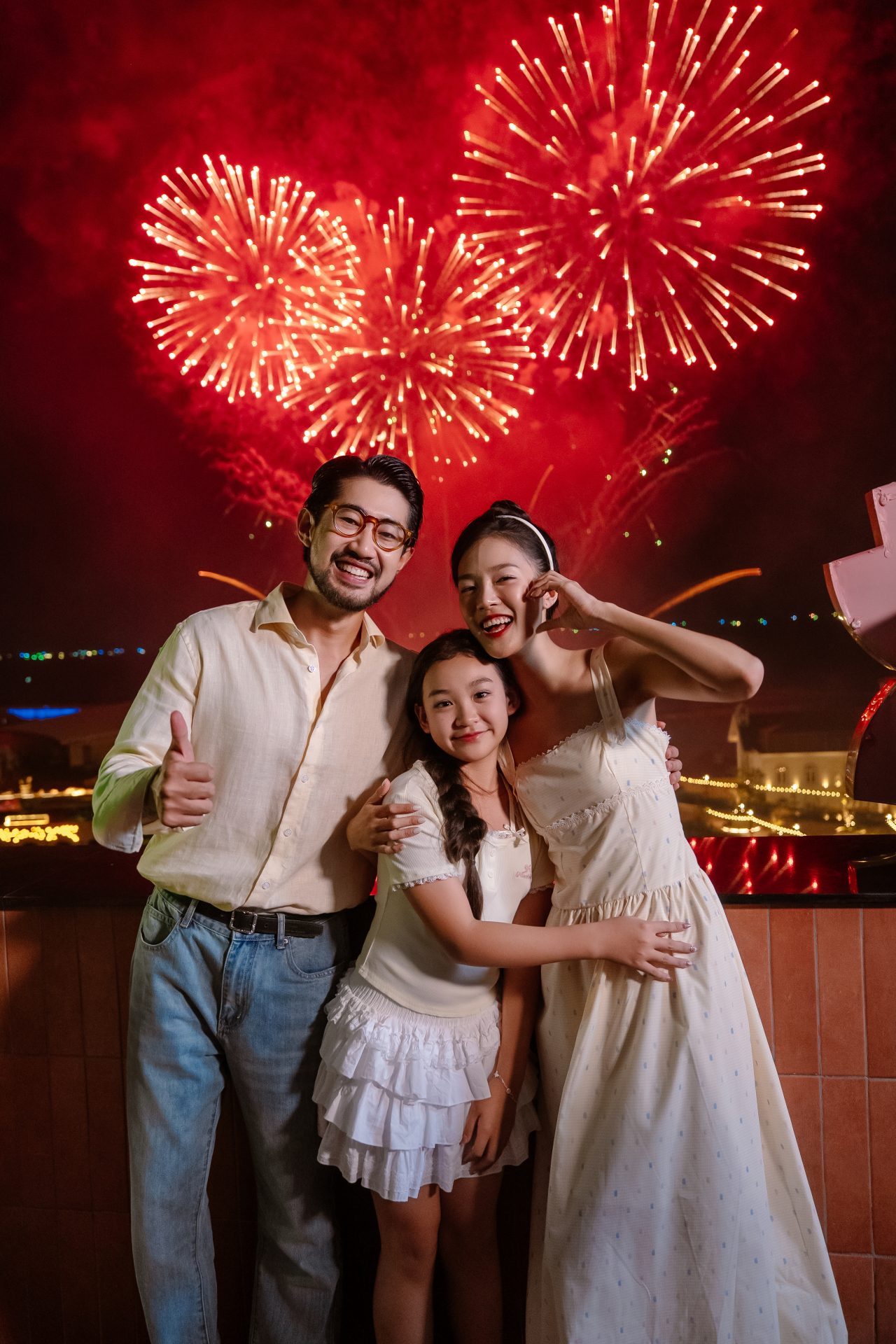 Family watching heart-shaped fireworks from a sea-facing balcony in Sunset Town, Phu Quoc