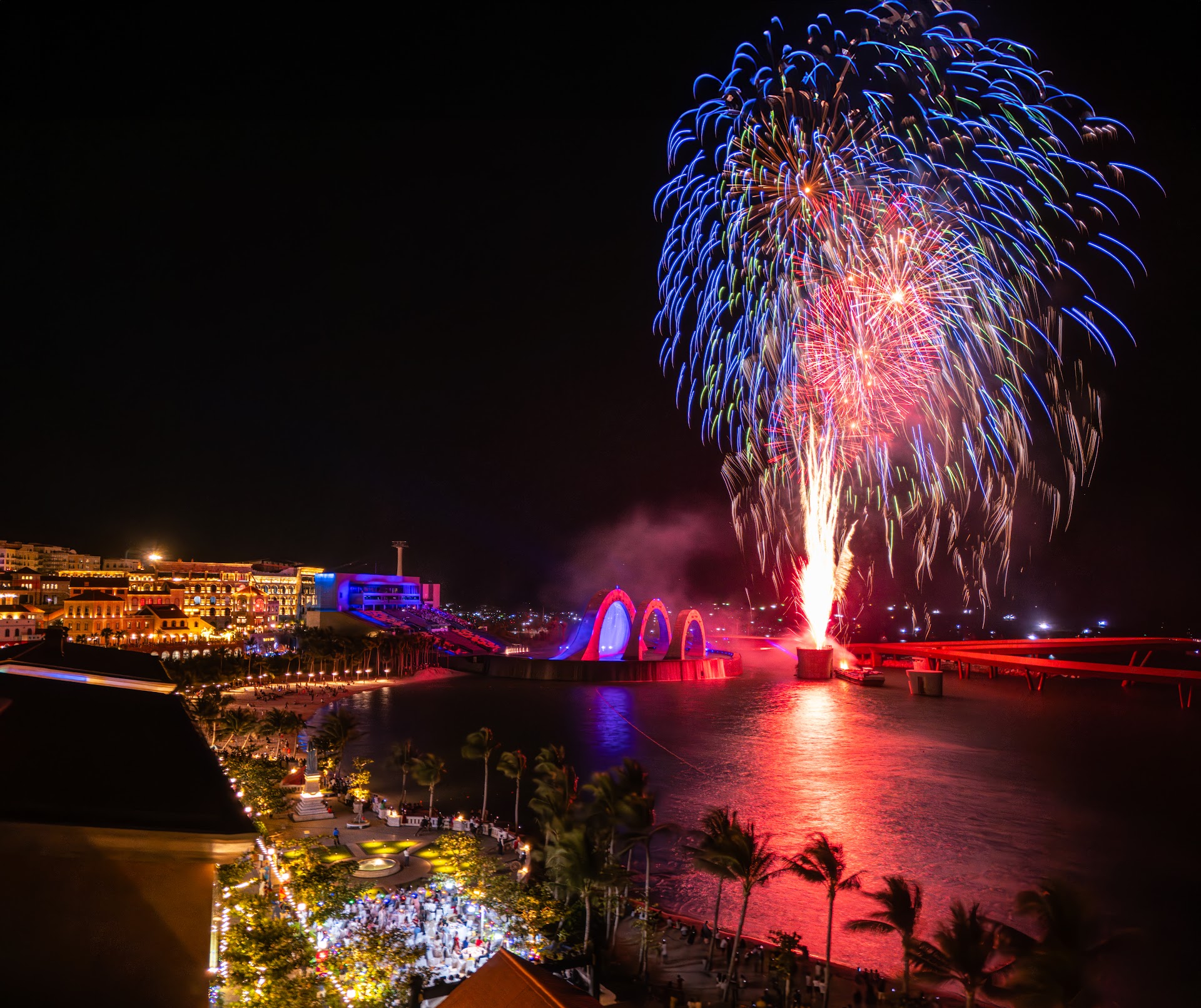 Fireworks bursting over the sea at Sunset Town, Phu Quoc, seen from above near Kiss Bridge