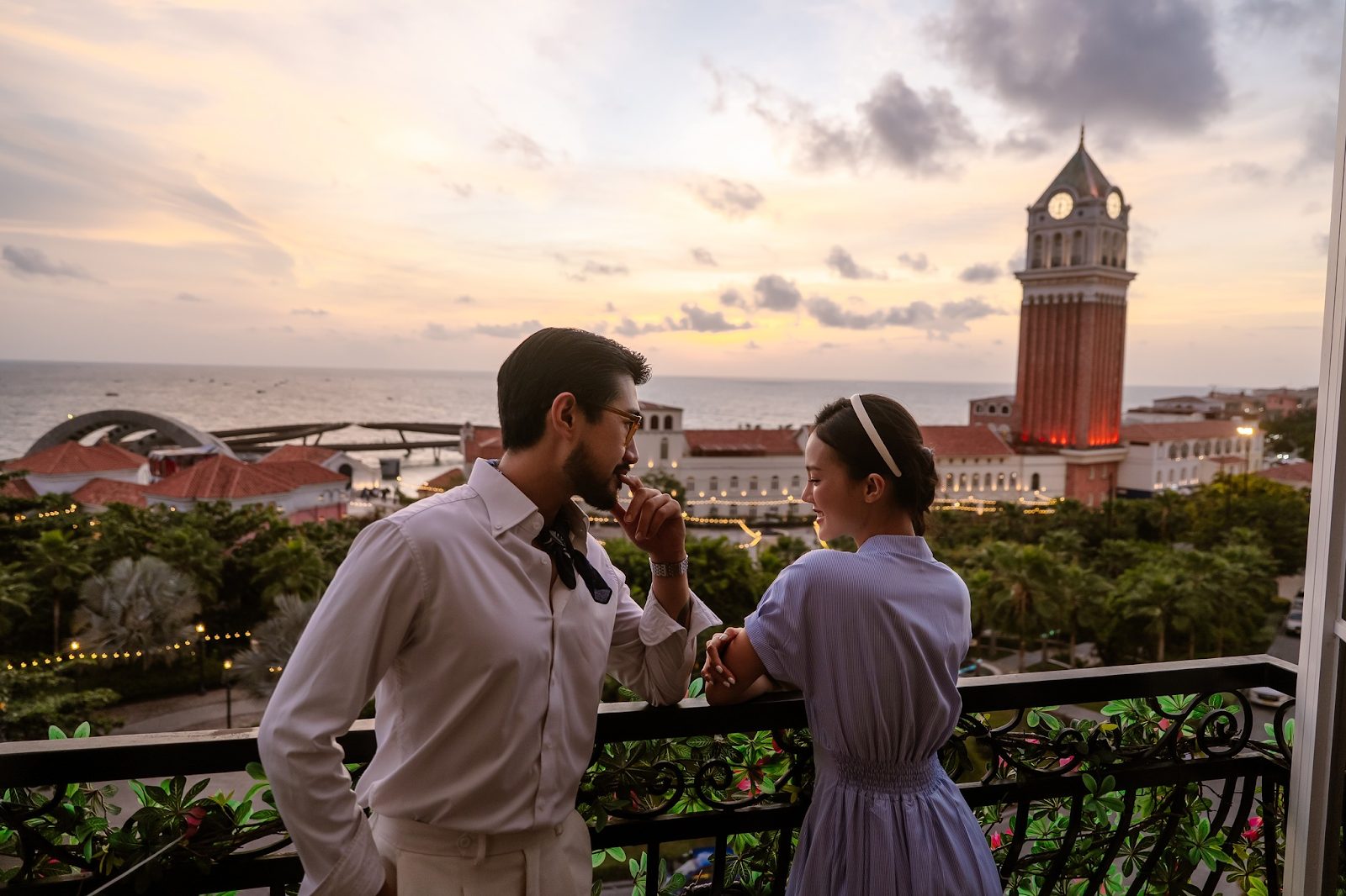 Couple looking at the sea from a sea-view balcony in Sunset Town